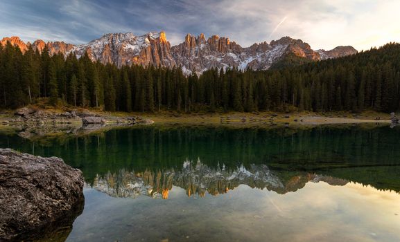 Sunset at Carezza lake with beautiful reflections of dolomites mountains