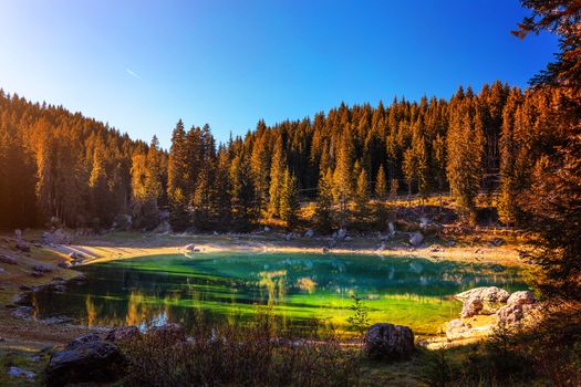 Sunny autumn day at Carezza lake, Dolomites, Italy