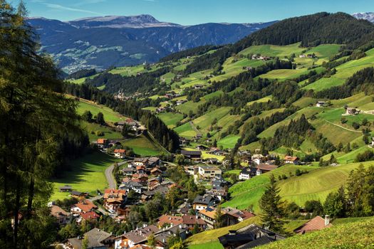 Val di Funes, Trentino Alto Adige, Italy. The great autumnal colors shines under the late sun with Odle on the background and Santa Magdalena Village on the foreground.