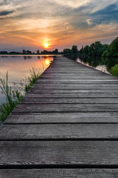 Wooden path over the lake at sunset