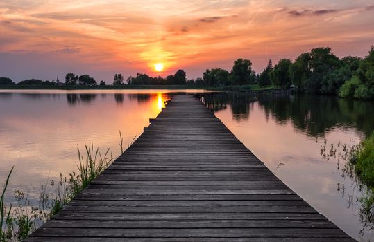 Wooden path over the lake at sunset