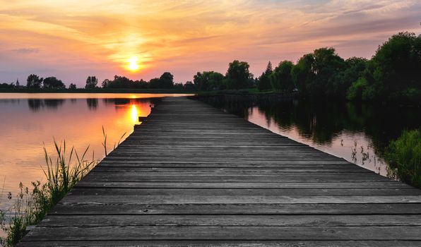 Wooden path over the lake at sunset