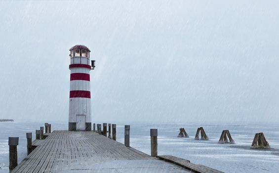 Lighthouse at sunrise with fog and rain during winter