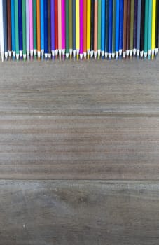 Top view many color pencils on wood background with copy space for text or design.