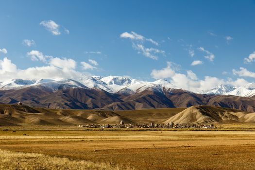 Cemetery in Kyrgyzstan at the foot of snow-capped mountains.