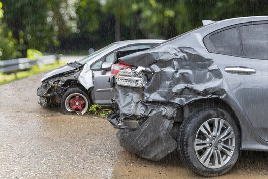 Raining day front of light gray color car crash with back side of  gray color car 2 car have damaged and broken by accident on road parking can not dirve any more.