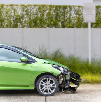 Front of green color car damaged and broken by accident on road parking can not dirve any more