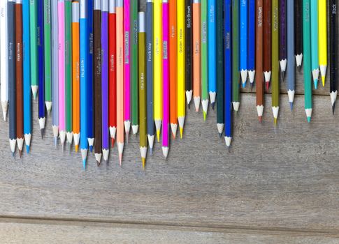 Many color pencils on wood table background with copy space for text or design