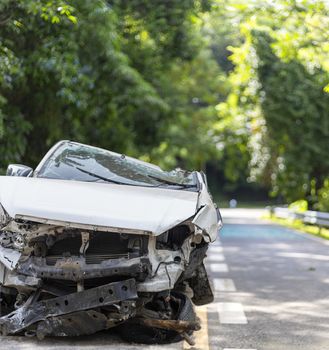 Front of white color car big damaged and broken by accident on road parking can not drive any more. With copy space for text or design