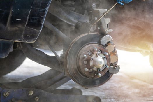 Mechanic use air gun clean disc break take dust removes before change break pat.