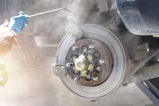 Mechanic use air gun clean disc break take dust removes before change break pat. Motion focus and forcus to disc break