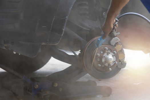 Mechanic use air gun clean disc break take dust removes before change break pat.