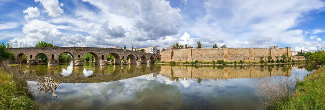 View of the Roman bridge of Merida with its reflection on the Guadiana river. Merida. Spain.The Archaeological Ensemble of Merida is declared a UNESCO World Heritage Site Ref 664. Panorama image from 5 original shots.