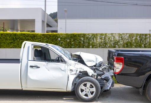 Front White color pack up car crash with back side black color car get damaged by accident on city street.