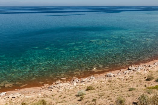clear water in Issyk-Kul Lake in Kyrgyzstan, stones under water at the bottom.