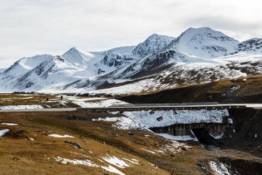 snowy mountain peaks on the Ala Bel pass, bridge on the Bishkek-Osh highway M41 in Kyrgyzstan