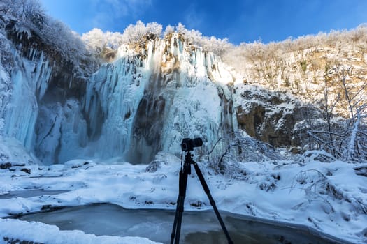 Preparing to take a picture of beautiful and frozen waterfall at plitvice lake, Croatia