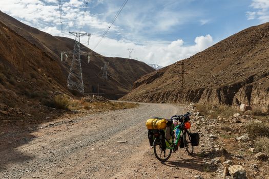 tourist bike with bags stand on the Mountain road, Kokemeren river in Kyrgyzstan