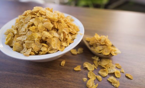 Corn flakes and bowl on wood table