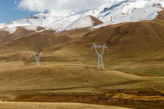 High voltage power line in Kyrgyzstan. Voltage electricity pylons in the mountains.