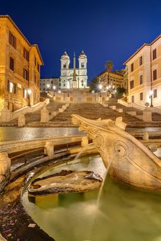 The famous Spanish Steps with a fountain in Rome at night