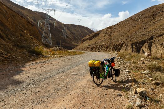 traveler's bike with bags stand on the Mountain road, Kokemeren river, Kyrgyzstan, tourist bike