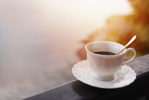 Morning coffee at balcony with sun rise and sun ray