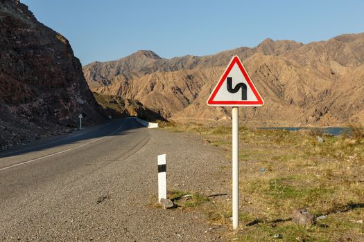 sign winding road on a mountain road, warning traffic sign kyrgyzstan