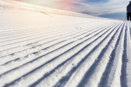 Close-up groomed snow at ski resort, slope banner background texture