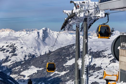 Gondola lift. Cabin of ski-lift in the ski resort in the early morning at dawn with mountain peak in the distance. Winter snowboard and skiing concept 