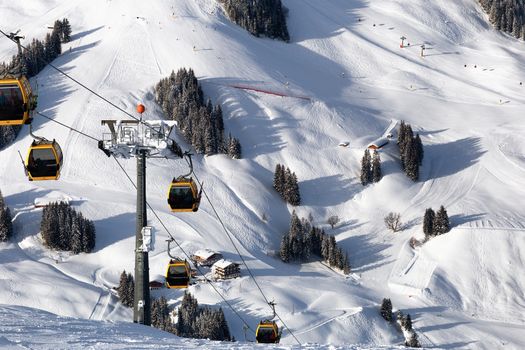 Gondola lift. Cabin of ski-lift in the ski resort in the early morning at dawn with mountain peak in the distance. Winter snowboard and skiing concept 