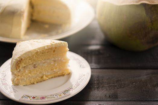 Coconut cream cake with coconut fruit on wood bakcground