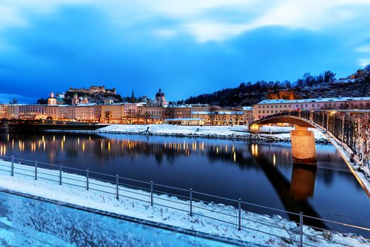 Beautiful view of the historic city of Salzburg with Salzach river in winter during blue hour, Salzburger Land, Austria