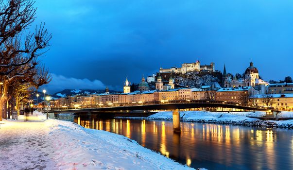 Classic view of the historic city of Salzburg with Salzburg Cathedral and famous Festung Hohensalzburg illuminated in winter, Salzburger Land, Austria