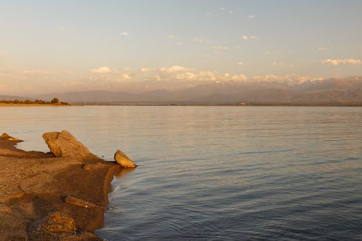 South shore of Issyk-kul lake in Kyrgyzstan, lake on a background of mountains at sunset