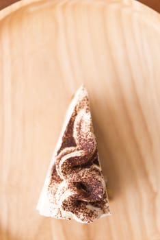 Banoffee pie with chocolate powder on wooden plate soft focus selective cake