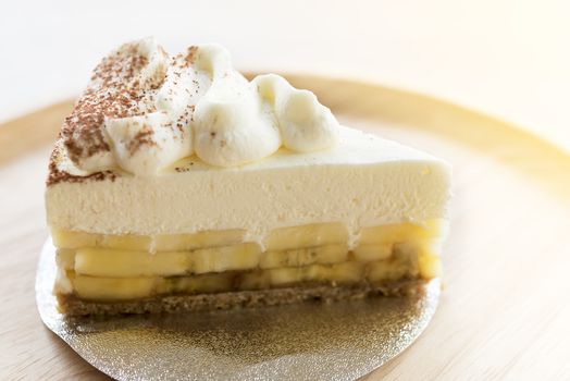 Banoffee pie with chocolate powder on wooden plate