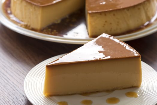  Homemade caramel custard pudding on white plate stay on wood table