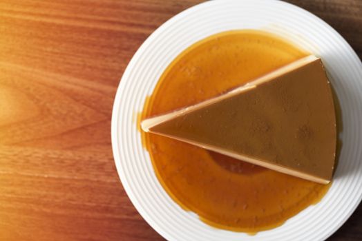  Homemade caramel custard pudding on white plate stay on wood table