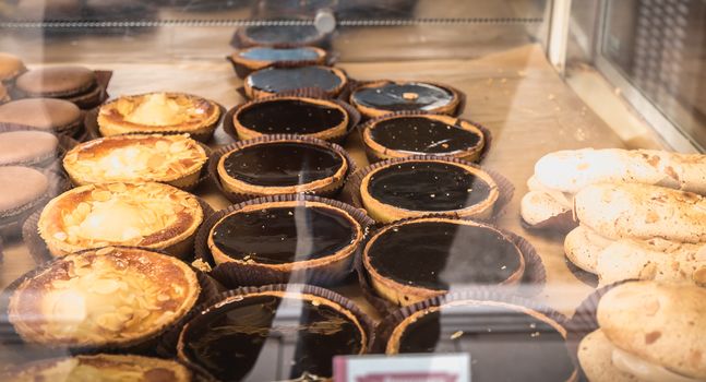 Port Joinville, France - September 16, 2018: Pastries and macaroons in the window of a downtown bakery on a summer day