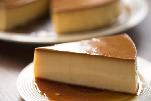  Homemade caramel custard pudding on white plate stay on wood table