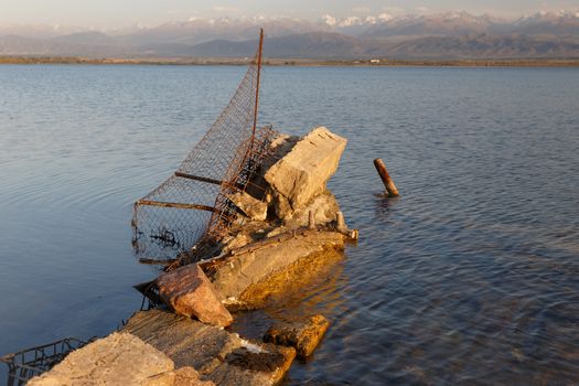 South shore of Issyk-kul lake in Kyrgyzstan, broken fence in the water