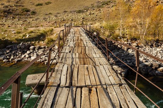 wooden bridge over a mountain river, Kokemeren river, Kyrgyzstan