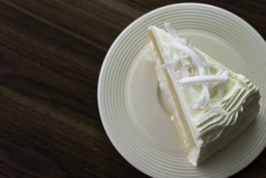A piece of coconut cake on white dish