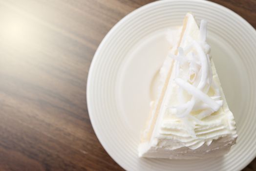 A piece of coconut cake on white dish