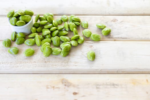 Bitter Beans on wood table. With copy space for text or design.