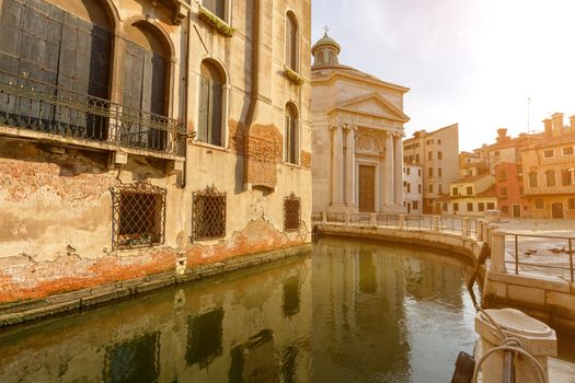 Small canal in venice with old buildings balconies a fading painted walls