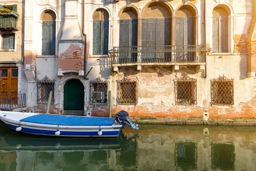 Small canal in venice with old buildings balconies a fading painted walls