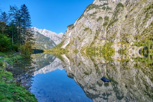 The lovely Obersee in the Bavarian Alps with a reflection of the mountains in the water