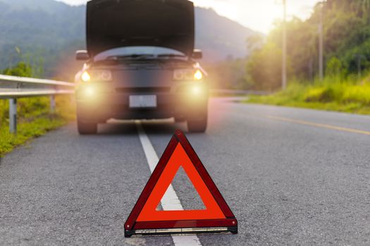 Red triangle, red emergency stop sign, red emergency symbol and black car stop and park on road.